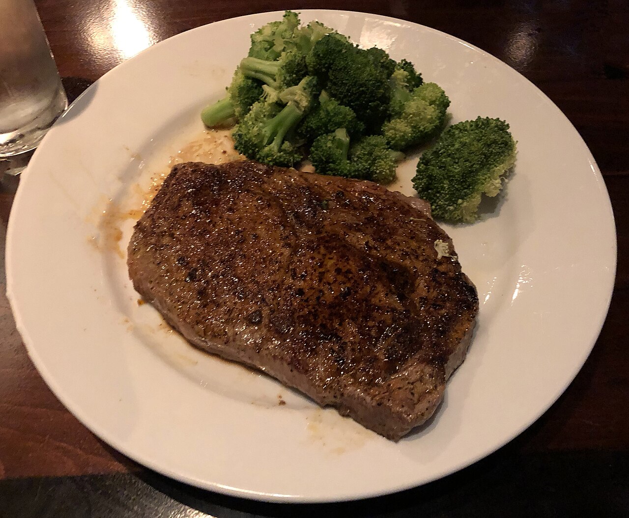 Grilled ribeye steak on a white plate